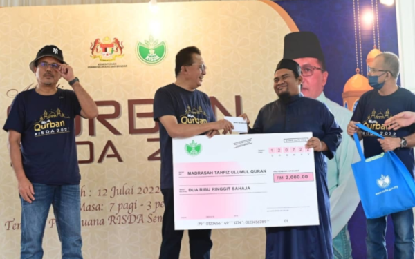 Mohd Salim (dua dari kiri) menyampaikan sumbangan sempena Program Korban Risda 2022 kepada wakil Madrasah Tahfiz Ulumul Quran, Redzuan Mohd Said (dua dari kanan) pada Majlis Korban Risda 2022 di Puri Buana @ RSSB, Bandar Baru Bangi pada Selasa.