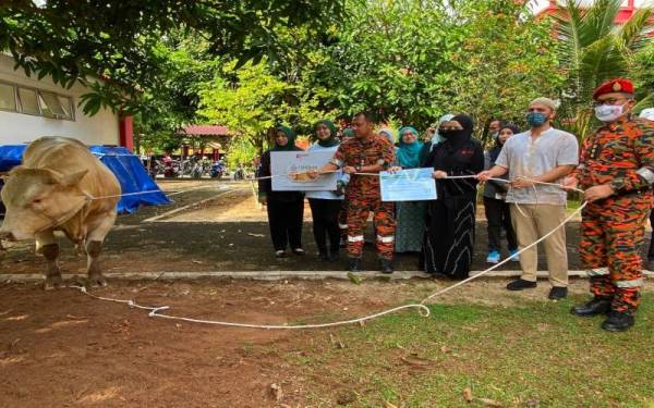 Neelofa (tiga dari kanan) bersama suami, PU Riz (dua dari kanan) dan Zainal (kanan) pada Majlis Korban Perdana JBPM Kelantan dengan kerjasama Pertubuhan Kasih Neelofa.