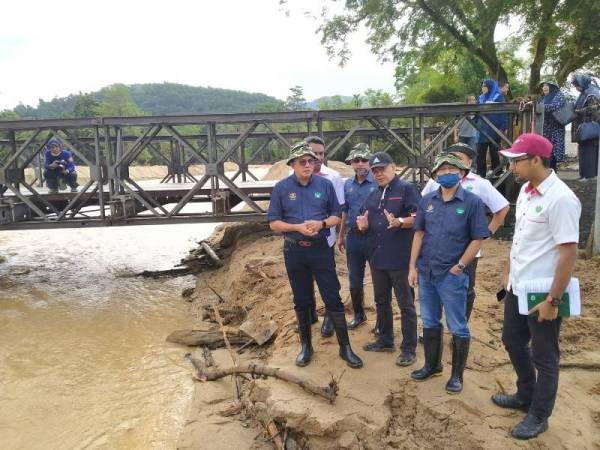 Pengerusi Risda, Datuk Seri Mohd Salim Mohd Sharif (kiri) melawat lokasi bencana banjir dan kepala air di tebing Sungai Iboi, Kupang, Baling, Kedah.