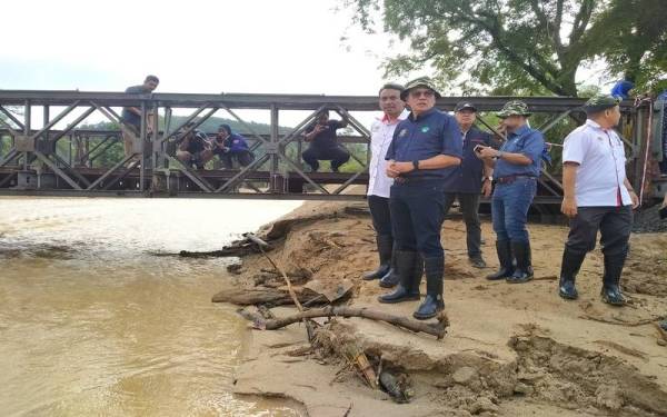 Mohd Salim (depan) meninjau kawasan di Kampung Iboi yang terjejas banjir.