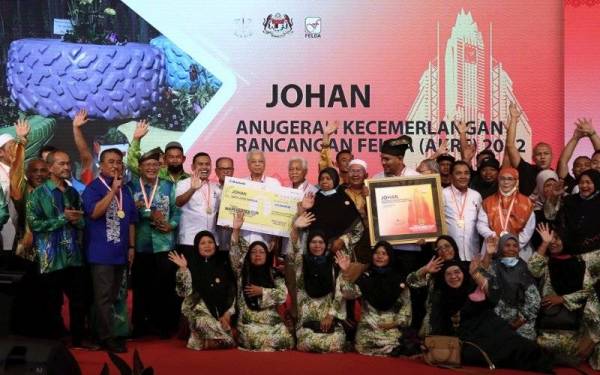 Ismail Sabri bersama sebahagian peneroka Felda Jengka 25 yang dinobatkan juara AKRF 2022 pada Majlis Sambutan Hari Peneroka Felda peringkat kebangsaan di Padang Awam Felda Rentam pada Khamis. - Foto Bernama