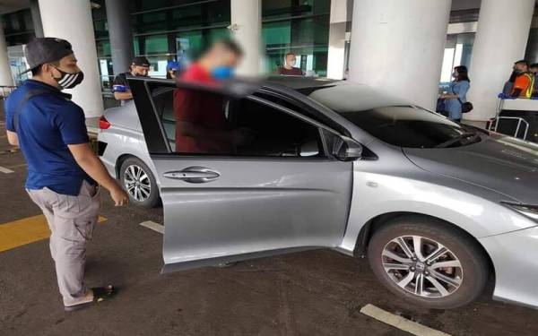 Dua 'ulat' ditahan kerana menawarkan perkhidmatan kereta sewa secara haram di KLIA. - Foto JPJ