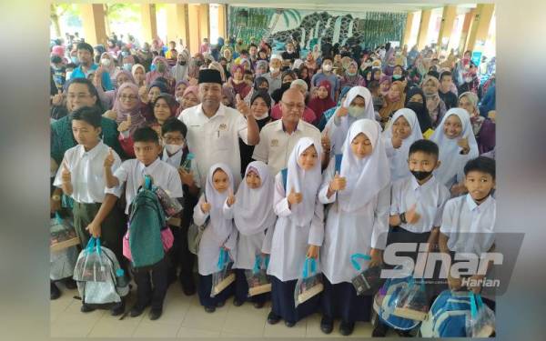 Abdul Azeez bersama sebahagian daripada pelajar yang menerima bantuan persekolahan akibat terjejas bencana banjir ketika hadir ke Program Agihan Set Seragam Sekolah bagi mangsa terkesan banjir di SMK Jerai, Kupang, Baling pada Sabtu.