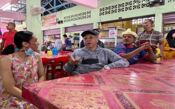 Annuar (dua dari kiri) beramah mesra dengan pengunjung Pasar Ketereh semasa program turun padang pada Sabtu.