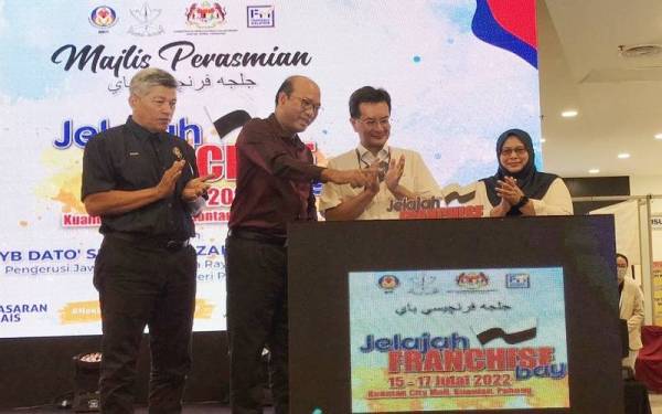 Azman (dua dari kiri) memberitahu sesuatu kepada Norolazali (dua kanan) ketika majlis perasmian Program Jelajah Francais Bay (PJFB) 2022 di Kuantan City Mall pada Sabtu.