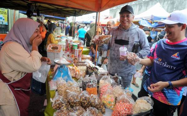 Annuar (dua dari kanan) beramah mesra bersama peniaga dan pengunjung di pasar Tani ketika mengadakan tinjauan harga barangan makanan di Pasar Ketereh pada Sabtu. - Foto Bernama