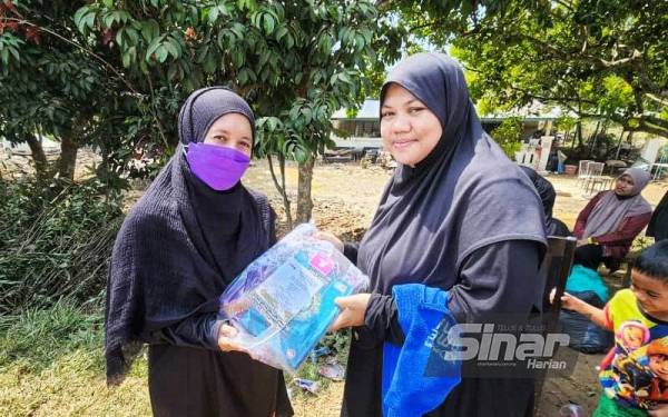 Rozalina menyampaikan sumbangan kepada salah seorang mangsa kepala air di Kampung Hangus di Kupang di sini.