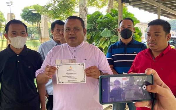 Mohd Sany menunjukkan wang RM100 dan surat jemputan untuk diserahkan kepada Ismail Sabri.