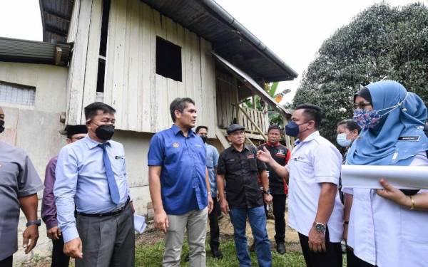 Dr Radzi Jidin (dua dari kiri) mendengar taklimat mengenai keadaan rumah guru Sekolah Kebangsaan Ansuan daripada Timbalan Pegawai Pendidikan Telupid/Tongod Jamain Bakut (dua dari kanan) sewaktu mengadakan lawatan ke sekolah itu pada Isnin. - Foto Bernama