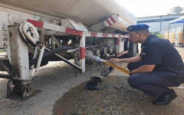 Ahmad Khuzairi memeriksa lori tangki yang digunakan oleh sindiket penyelewengan diesel bersubsidi yang ditemui di sebuah premis di kawasan Perindustrian Mahsan pada Isnin. Foto: KPDNHEP Kuala Pilah