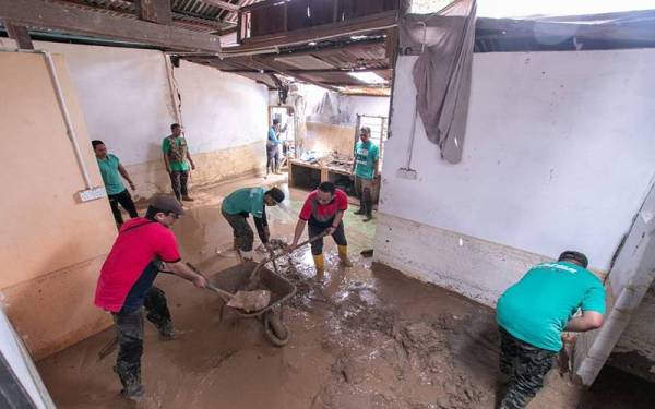 Pasukan peduli asnaf mengadakan gotong royong membersihkan rumah mangsa banjir di Kampung Iboi, Baling.