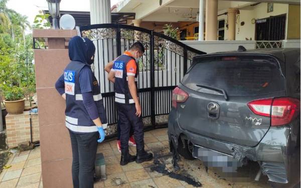 Pasukan Forensik sedang memeriksa Perodua Myvi milik seorang guru pusat tuisyen di Taman Baiduri di sini yang terbakar.