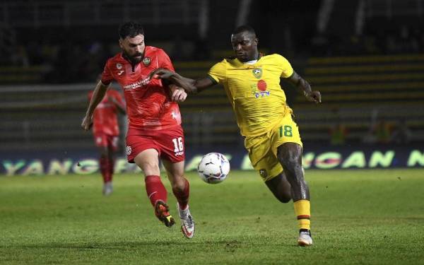 Pemain Kedah, Wanja Ronald Ngah (kanan) diasak kapten Sarawak United, Stuart James Wilson Wark ketika perlawanan Liga Super di Stadium Darul Aman.