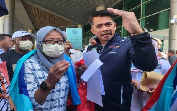 Mohd Azis (kanan) dan Isnaraissah Munirah (depan kiri) ketika ditemui pemberita di KKIA, Kota Kinabalu pada Jumaat.