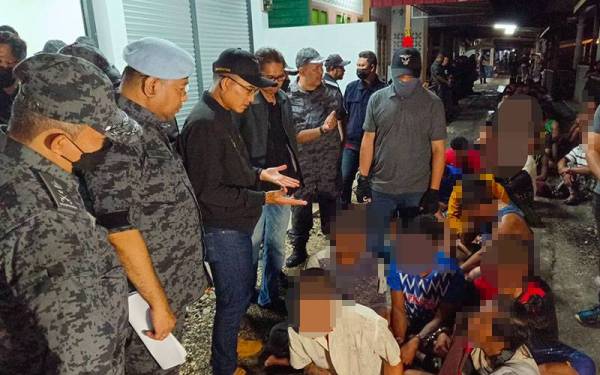 Khairul Dzaimee (tiga dari kiri) melihat kejayaan pasukan Imigresen menahan PATI yang didapati bekerja sebagai nelayan dan kilang memproses belacan di Kuala Gula pada Jumaat.