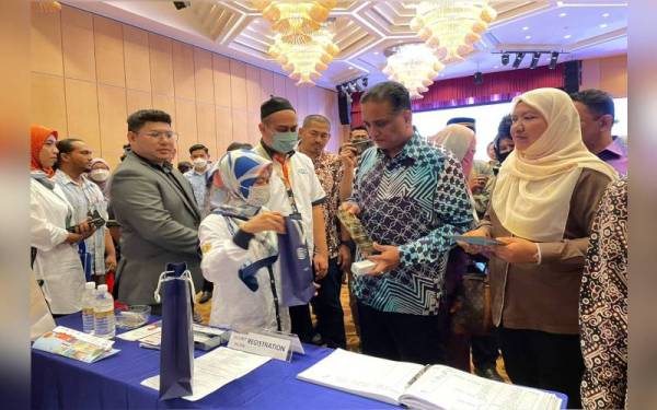 Reezal (tengah) sedang melihat produk ketika membuat lawatan di reruai selepas merasmikan Himpunan Usahawan Bumiputera Pulau Pinang 2022 pada Sabtu.