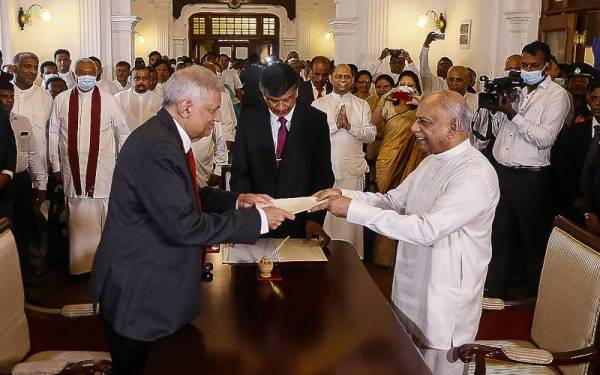 Gunawardena (kanan) mengangkat sumpah jawatan sebagai Perdana Menteri baharu Sri Lanka di hadapan Wickremesinghe di Colombo pada Jumaat. - Foto AFP