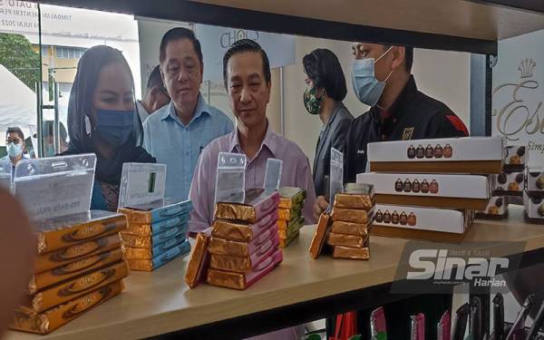 Jeck Seng (tengah) melihat produk yang dipamerkan di Pusat Keusahawanan Coklat Tanjung Piai di Pekan Nanas pada Ahad.