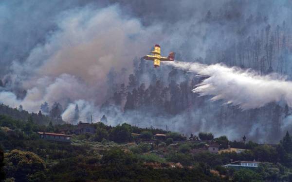 Sebuah pesawat hidro mencurahkan air bagi memadamkan kebakaran hutan di La Orotava, Tenerife, Pulau Canary, Sepanyol. - Foto EPA 