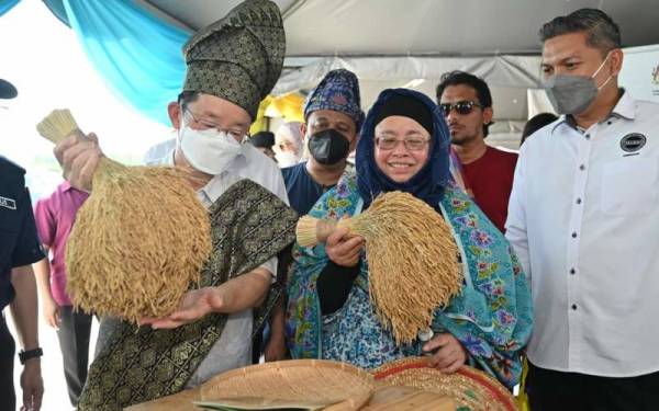 Kon Yeow (kiri) membanting padi ketika meninjau pameran Pesta Padi Antarabangsa Pulau Pinang 4.0 yang dianjurkan di Kampung Terus, Penanti pada Ahad.