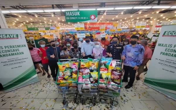 Barisan tetamu dan penerima baucar bergambar bersama pada majlis perasmian di Econsave Pandamaran pada Ahad.