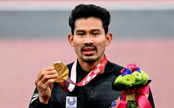 IMBAS KEMBALI...Abdul Latif memenangi pingat emas bagi acara lompat jauh T20 dengan lompatan sejauh 7.45 meter (m) pada Sukan Paralimpik Tokyo 2020 di Stadium Olimpik, 4 September tahun lalu. - Foto Bernama