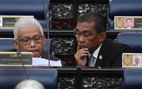 Menteri Tenaga dan Sumber Asli yang juga Ahli Parlimen Kota Bharu Datuk Seri Takiyuddin Hassan(kanan) bersama Menteri Dalam Negeri yang juga Ahli Parlimen Larut Datuk Seri Hamzah Zainudin ketika Mesyuarat Kedua Penggal Kelima Parlimen ke-14 bagi Persidangan Dewan Rakyat di Bangunan Parlimen, pada Selasa.
