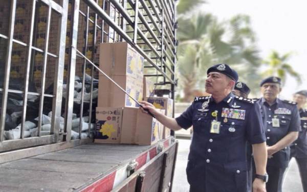 Muhammad Zaki menunjukkan daun ketum yang disembunyikan di belakang kotak gandum bagi mengaburi mata pihak berkuasa.