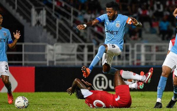 Pemain PJ City FC, K.Gurusamy cuba melepasi kekangan daripada pemain Sabah FC, Gary Steven Robbat (bawah) pada aksi Liga Super di Stadium MBPJ pada Selasa. - Foto Bernama