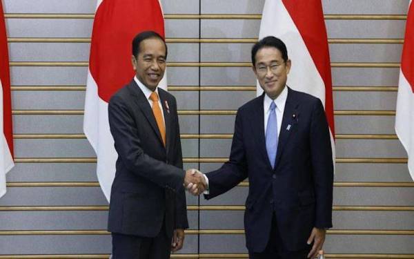 Jokowi (kiri) disambut Kishida (kanan) ketika Presiden Indonesia itu dalam rangka lawatan ke Jepun. Foto AFP/Kisyoshi Ota