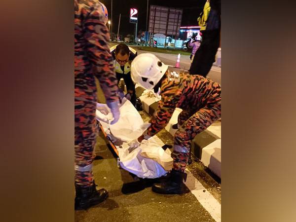 Anggota bomba mengangkat mayat Zairul Shahrizal selepas maut dalam kemalangan berhampiran Kayu Ara Pasing, Jalan Pontian-Benut, Pontian, pada Khamis.