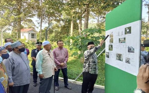 Ahmad (tiga dari kanan) melihat carta aliran LRA proses rawatan air di LRA Tualang 2, Kuala Krai.