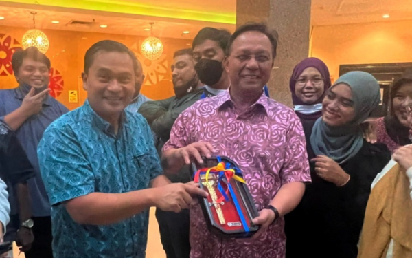 Mohamad Fauzi (kiri) menyampaikan cenderamata kepada Hasni semasa Majlis BBQ Santai KMJ di Johor Bahru pada malam Khamis.