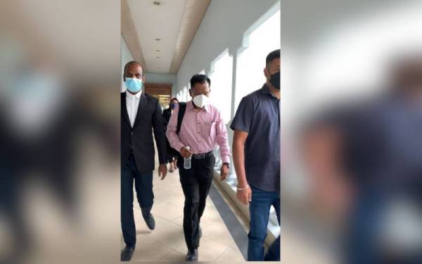 Vijaya Kumar (dua dari kiri) hadir di Mahkamah Sesyen Kuala Lumpur pada Jumaat untuk menghadapi pertuduhan kes menggunakan dokumen pembayaran baucar palsu.