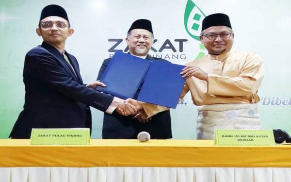 Roslan (tengah) menyaksikan pertukaran MoU antara Mohamad Kairi (kiri) dan Mohd Nazri (kanan) dalam majlis yang diadakan di Ibu Pejabat ZPP pada Jumaat.