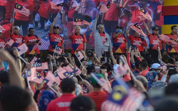 Perdana Menteri Datuk Seri Ismail Sabri Yaakob dan Annuar mengibarkan Jalur Gemilang bersama para peserta &#039;Berjalan Teguh Bersama&#039;. - Foto Bernama