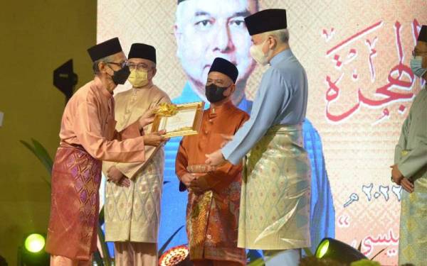 Sultan Nazrin (kanan) menyampaikan Anugerah Tokoh Maal Hijrah Negeri Perak pada Majlis Sambutan Maal Hijrah 1444 Peringkat Negeri Perak di Bandar Meru Raya pada Sabtu.