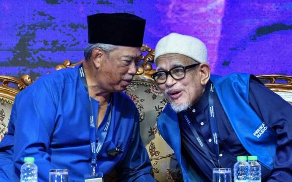 Muhyiddin (kiri) memperkatakan sesuatu kepada Abdul Hadi pada Majlis Pelancaran Perikatan Nasional Peringkat Terengganu di Masjid Rusila malam tadi. - Foto Bernama