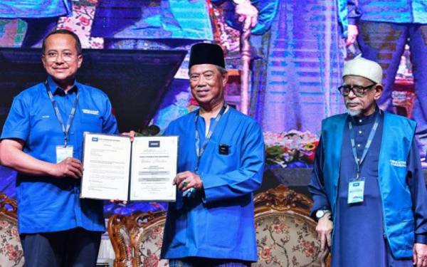 Muhyiddin (tengah) menyerahkan watikah lantikan Ahmad Samsuri (kiri) pada Majlis Pelancaran Perikatan Nasional Peringkat Terengganu di Masjid Rusila malam tadi. - Foto Bernama