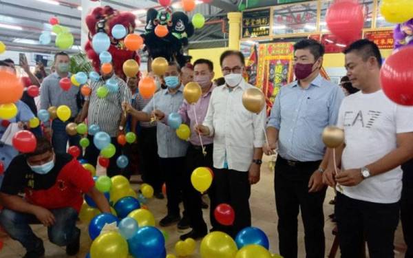 Anwar (tiga kanan) ketika merasmikan Dataran Segar Huat Huat Food Court di Lukut, pada Ahad.