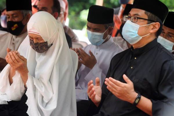 Isteri arwah, Puan Seri Salbiah Tunut (kiri) mengaminkan bacaan doa selepas selesai pengkebumian jenazah suaminya yang juga bekas Menteri Besar Selangor, Tan Sri Abdul Khalid Ibrahim di Makam DiRaja Shah Alam pada Isnin. - Foto Bernama