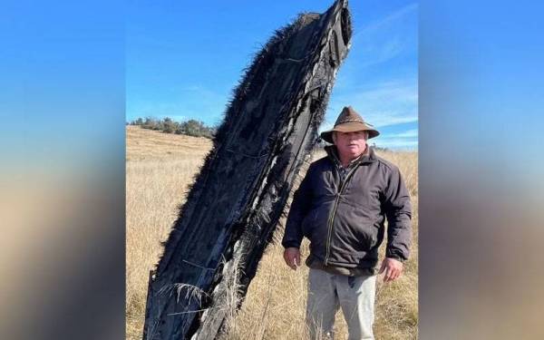 Mick Miners bergambar bersama serpihan roket yang tertusuk ke dalam tanah miliknya di Jindabyne baru-baru ini. - Foto Mick Miners