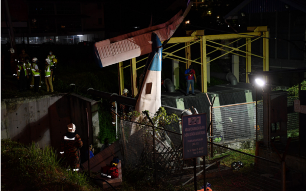 Pegawai dan anggota keselamatan melakukan kerja-kerja mengeluarkan mayat jurulatih penerbangan yang maut selepas pesawat ringan jenis Piper 28 terhempas di Jalan Dr Nazrin Shah berhampiran Medan Gopeng malam Isnin. - Foto Bernama 