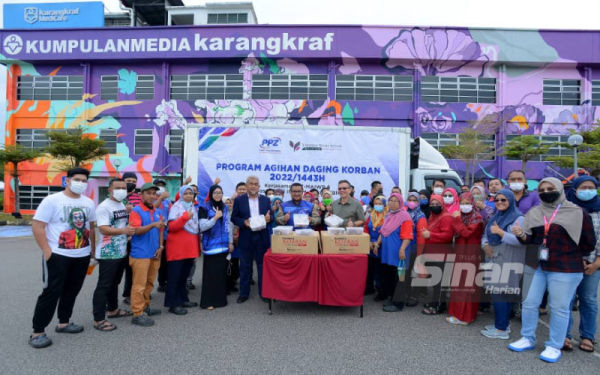 (Depan, enam dari kiri) Hashim, Fahmi dan Akmal Eirfan bersama penerima sumbangan daging korban sejuk beku
di hadapan Kompleks Karangkraf, Shah Alam pada Selasa.