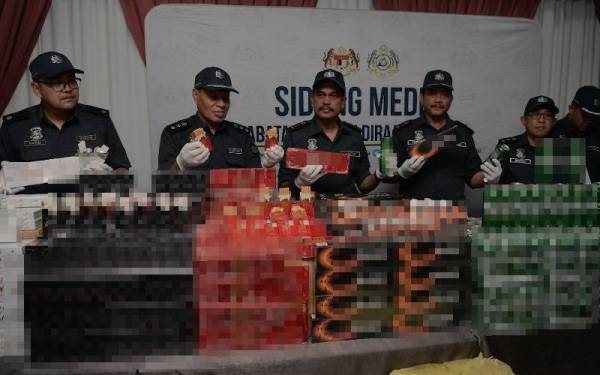 Sazali (kanan) menunjukkan rokok putih dan kretek yang dirampas dalam serbuan di sebuah gudang di Kulai ketika sidang akhbar di Menara JKDM Johor, Larkin, Johor Bahru pada Rabu.