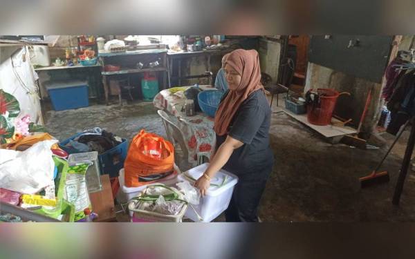 Noor Ezaini mengemas barang di rumahnya sebagai persiapan berdepan banjir kilat susulan hujan yang dijangka sehingga Ahad di kawasan Johor Bahru.