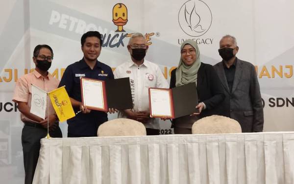 Anif (dua dari kiri) dan Nurul Hamizah (dua dari kanan) selepas menandatangani perjanjian sambil disaksikan oleh Noh (tengah) pada Majlis Pelancaran Produk Aductive Food Sdn Bhd (Aductive) ke semua rangkaian Mesra Petronas di Glenmarie Hotel & Golf Resort, di sini pada Rabu.