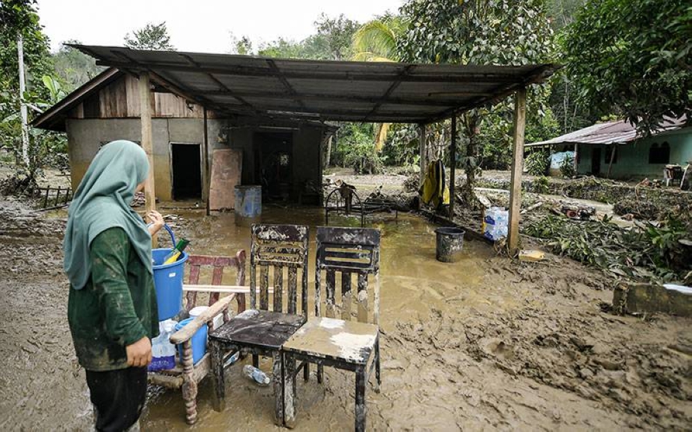 Penduduk kampung mengeluarkan perabot bersalut lumpur ketika membersihkan kawasan rumah mereka berikutan banjir kilat di Kampung Teluk Sanau, Batu 7, pada Selasa. Sementara itu, jumlah mangsa banjir di dua PPS di Baling berkurangan kepada 27 orang pagi ini. - Foto Bernama