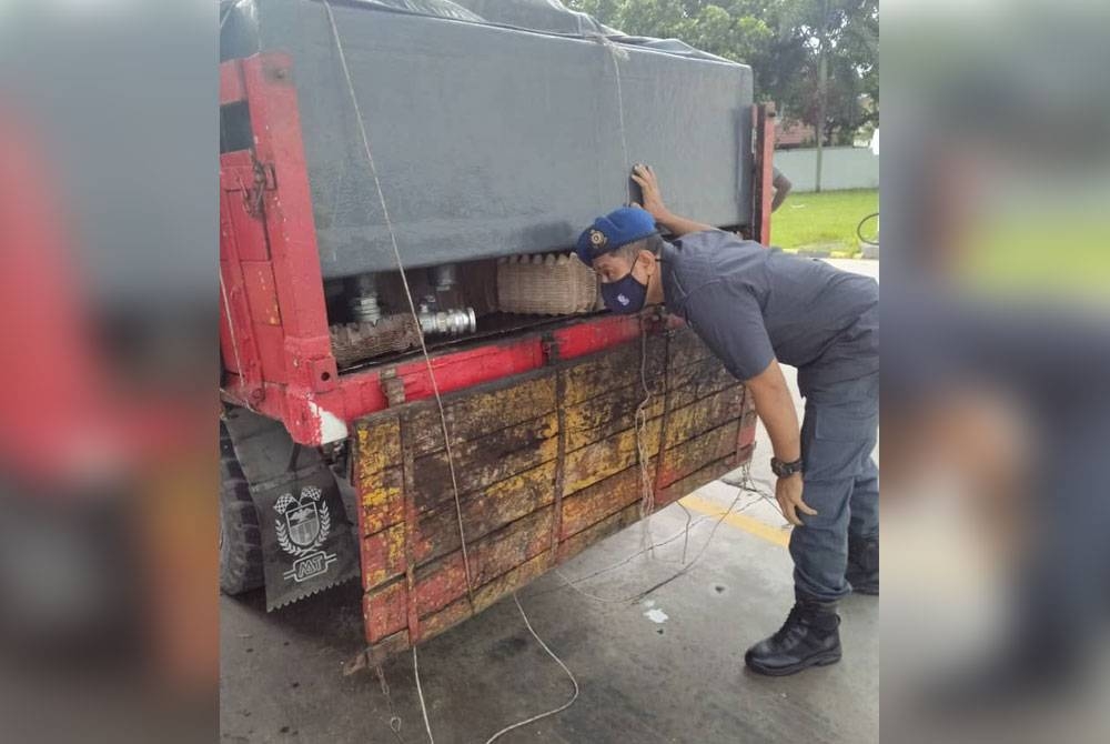 Seorang penguat kuasa KPDNHEP Pulau Pinang memeriksa lori yang dirampas dalam serbuan di sebuah stesen minyak di Jalan Baru pada Rabu.