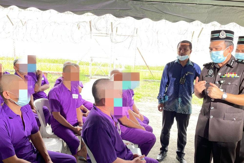 Mohamad Jusoh (kanan) berbual bersama penghuni selepas Majlis Sambutan Maal Hijrah di Penjara Reman Pulau Pinang pada Khamis.